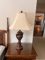 Full view of first lamp on side table showing shade and base