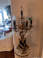 Full view of candelabra front showing six arms, bulbs, crystals and base