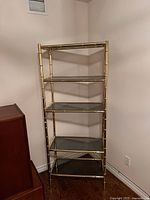 Full front view showing entire five-shelf brass and glass étagère