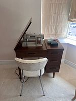 Front view of Brother Opus 191 sewing machine in cabinet with chair