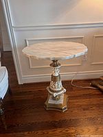 Full view of side table angled showing marble top and base