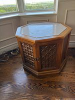 Full view of octagonal side table showing marble top and carved doors
