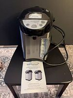 Full view of Brentwood hot water dispenser with attached cord and user manual