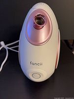 Front view of Fancii white facial steamer with rose-gold nozzle and power button