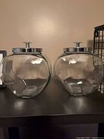 Two identical round glass jars with stainless lids