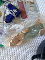 Bag of wooden discs, glass cabochons, blue glue gun, partial view of photo sleeve pack