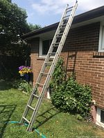 Ladder extended against brick wall full view