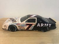 Left side profile of die-cast car showing desert camouflage livery and #7 graphics