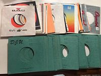 Assorted BMG and multicolour sleeves stacked above green DJU sleeves