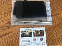 Folded black mesh gate, metal rods, white hooks on surface