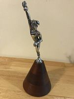 Full view of figurine mounted on conical wood base