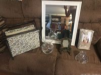 All items arranged on sofa: magazine rack, glass vases, mirror, small frame, light shade, packaged chair cover