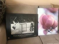 Both prints side by side on couch: hockey poster and magnolia canvas