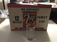 Front of 7UP cardboard case with glass in front