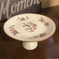 Side view of Birks pedestal plate with floral and bird motif on pedestal base