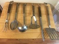 Six utensils hanging on rack on table