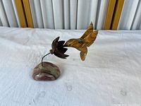 Full view of hummingbird, flower and stone base