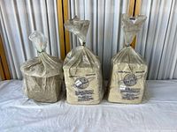 Three clay cubes in plastic bags, two branded, one plain