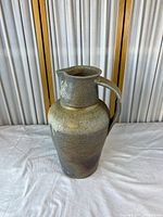 full view of tall ceramic vase with handle