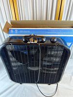 Front view of black Lasko box fan outside its carton