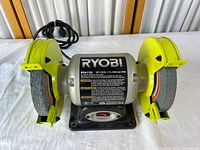 Front view of Ryobi BG612G bench grinder showing wheels and power cord