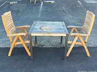 Overall view showing square teak table and two matching folding chairs