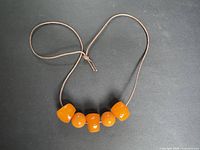Full view of necklace showing leather cord and five Bakelite beads