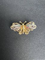 Front view of butterfly filigree brooch on black background