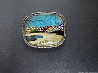 Front view of brooch showing painted landscape