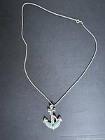 Full view of necklace and pendant on dark background