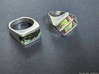 Top view of two sterling silver rings showing inlays and geometric shapes