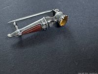 Side view of dagger brooch showing stones and clasp