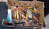 Cardboard box filled with assorted hand tools and accessories