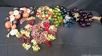 Overview of lucite grape clusters, onion-eggplant garland and several plastic grape bunches