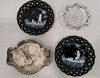 Group shot of two black plates, clear bowl, silver-tone candy dish