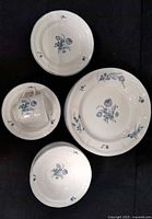 Overhead view of example dinner plate, bowl, teacup and stacks showing blue floral pattern