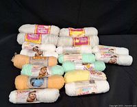 Group of pastel baby yarn skeins showing brands and colors