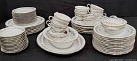 Stacks of dinnerware showing plates, cups, bowls, sugar bowl