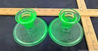 pair of green uranium glass candle holders top and side view with ruler for scale