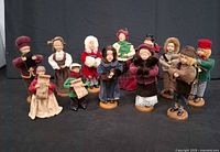 Twelve standing Christmas caroler figures displayed together