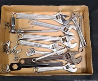 Box with assorted adjustable wrenches, crowfoot wrenches, socket, black spanner