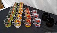 Array of Garfield glass mugs and two black ceramic mugs
