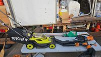 Ryobi mower, WORX blower/vac and hedge trimmer on table