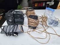 overview showing four satellite speakers, control pod, wires, zip bag of hardware