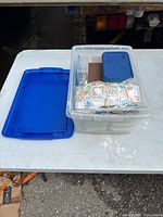 Top view of open clear tote showing bundled loose stamps and small containers