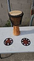 Djembe front with both carved trivets on table