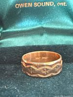 Angled view of gold band showing exterior engraving and 10K hallmark