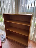 Front view of wood laminate bookcase showing two adjustable shelves and base shelf