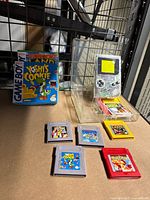 Lot overview showing clear Game Boy, five cartridges and two game boxes