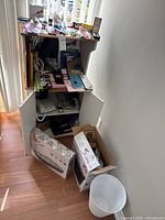 Entire shelving unit and floor showing boxed shredder, clipboards, office supplies